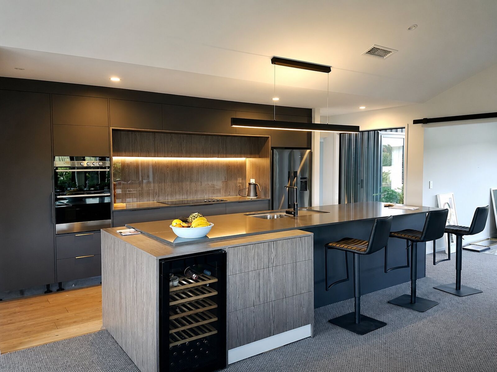 Charcoal kitchen cabinetry finished with a timber island