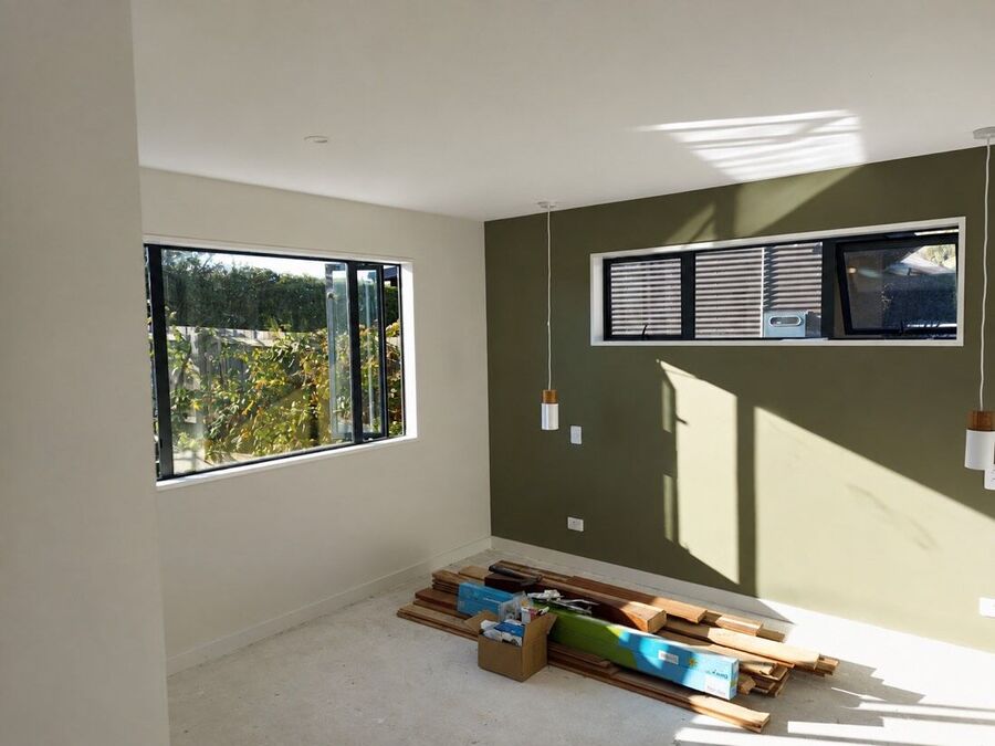 Olive feature wall mid job with timber and materials staged on the floor